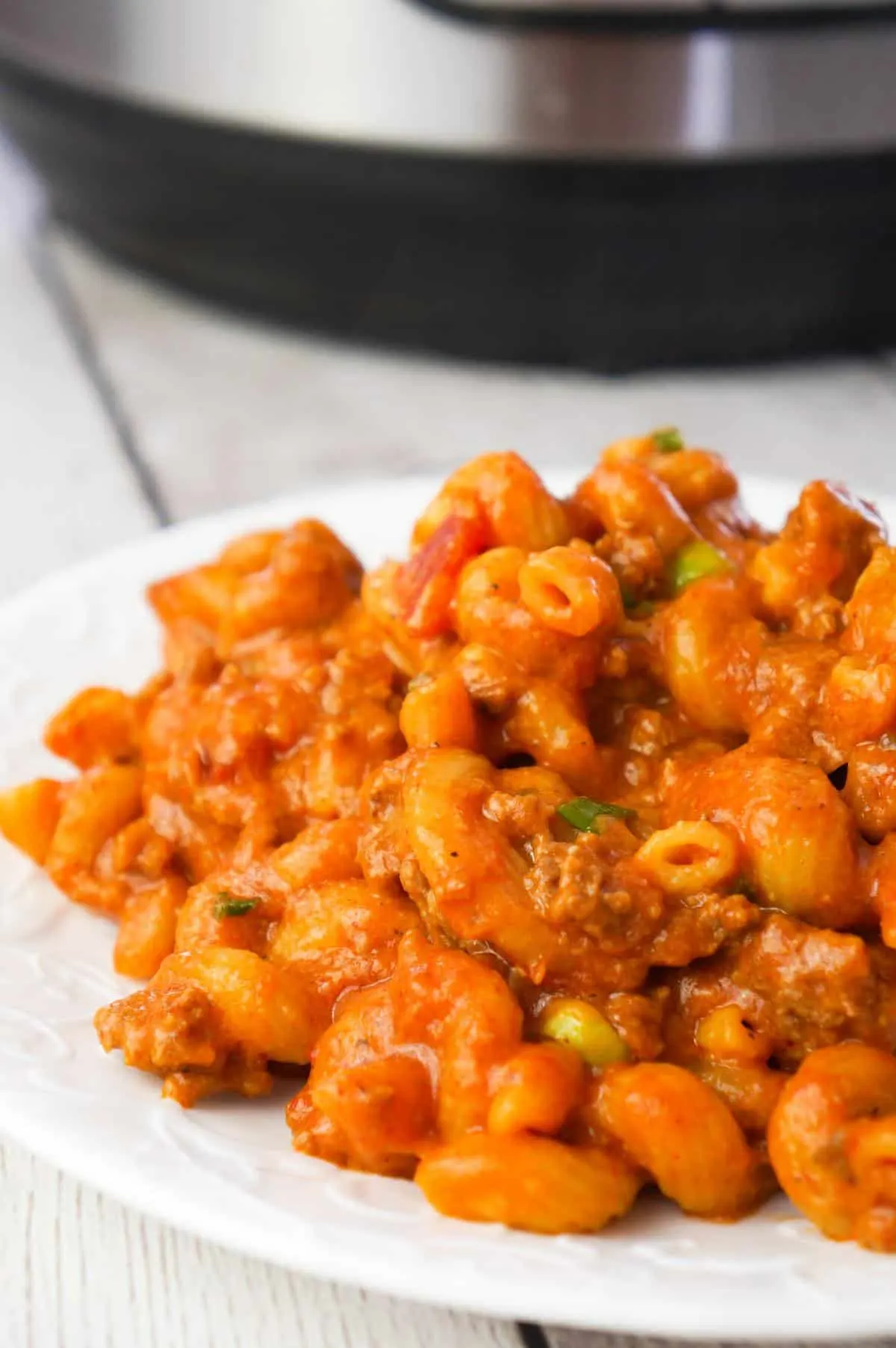 Instant Pot Cheesy Taco Pasta is a delicious pressure cooker pasta recipe loaded with ground beef, salsa, chili sauce, taco seasoning, chopped green onions and shredded cheese.