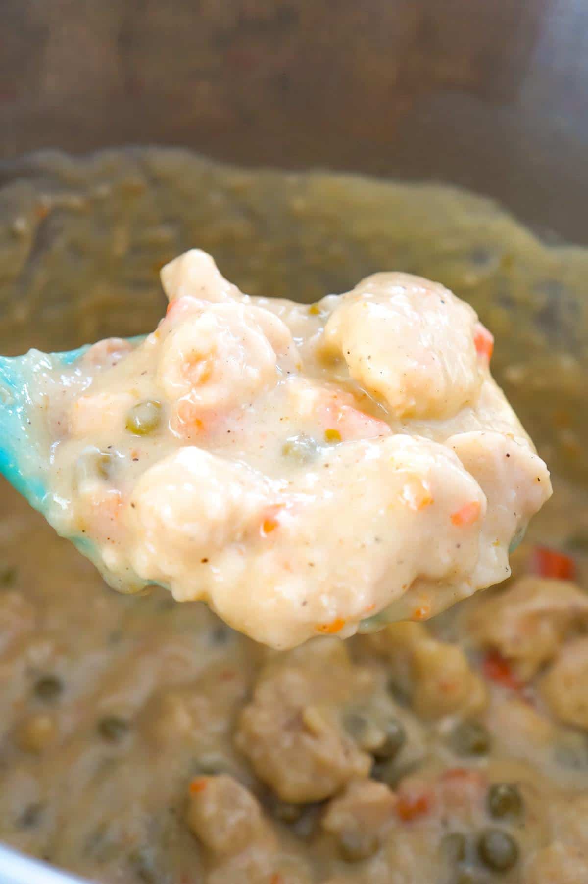 Instant Pot Chicken and Dumplings with Biscuits is an easy dump and start recipe using boneless, skinless chicken breasts, cream of chicken soup, Pillsbury refrigerated biscuits and canned peas and carrots.