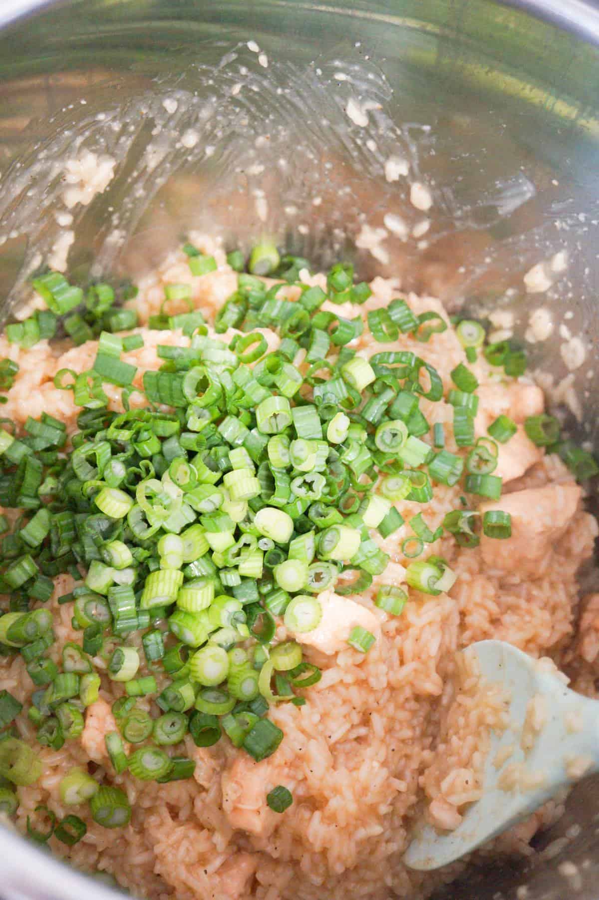chopped green onions on top of cooked chicken and rice in an Instant Pot