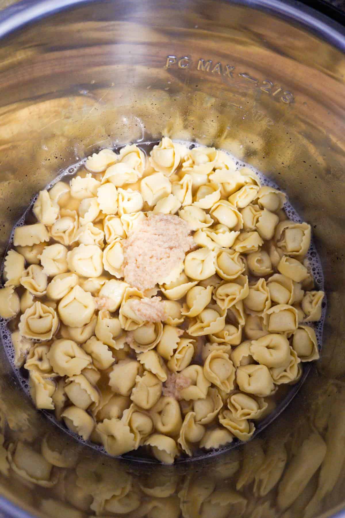 garlic puree on top of uncooked tortellini in an Instant Pot