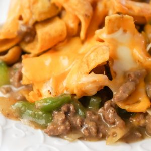 Philly Cheese Steak Frito Pie is an easy ground beef casserole recipe loaded with green peppers, onions, Fritos corn chips and shredded mozzarella and cheddar cheese.