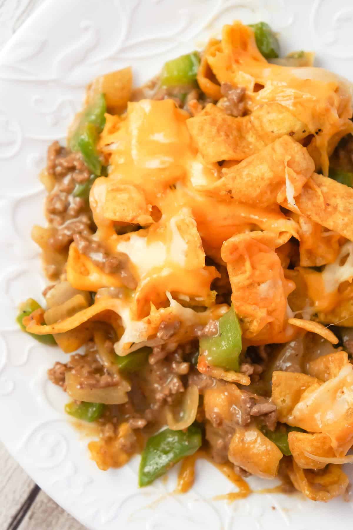 Philly Cheese Steak Frito Pie is an easy ground beef casserole recipe loaded with green peppers, onions, Fritos corn chips and shredded mozzarella and cheddar cheese.