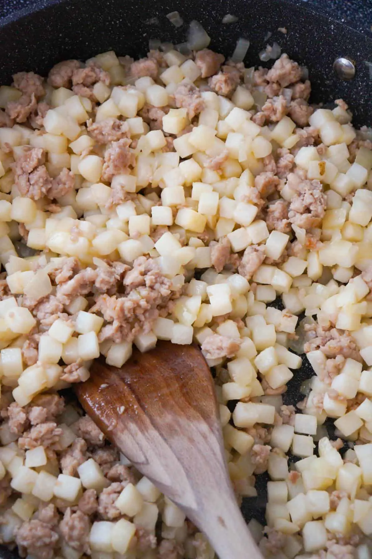 sausage meat and diced potatoes in a saute pan