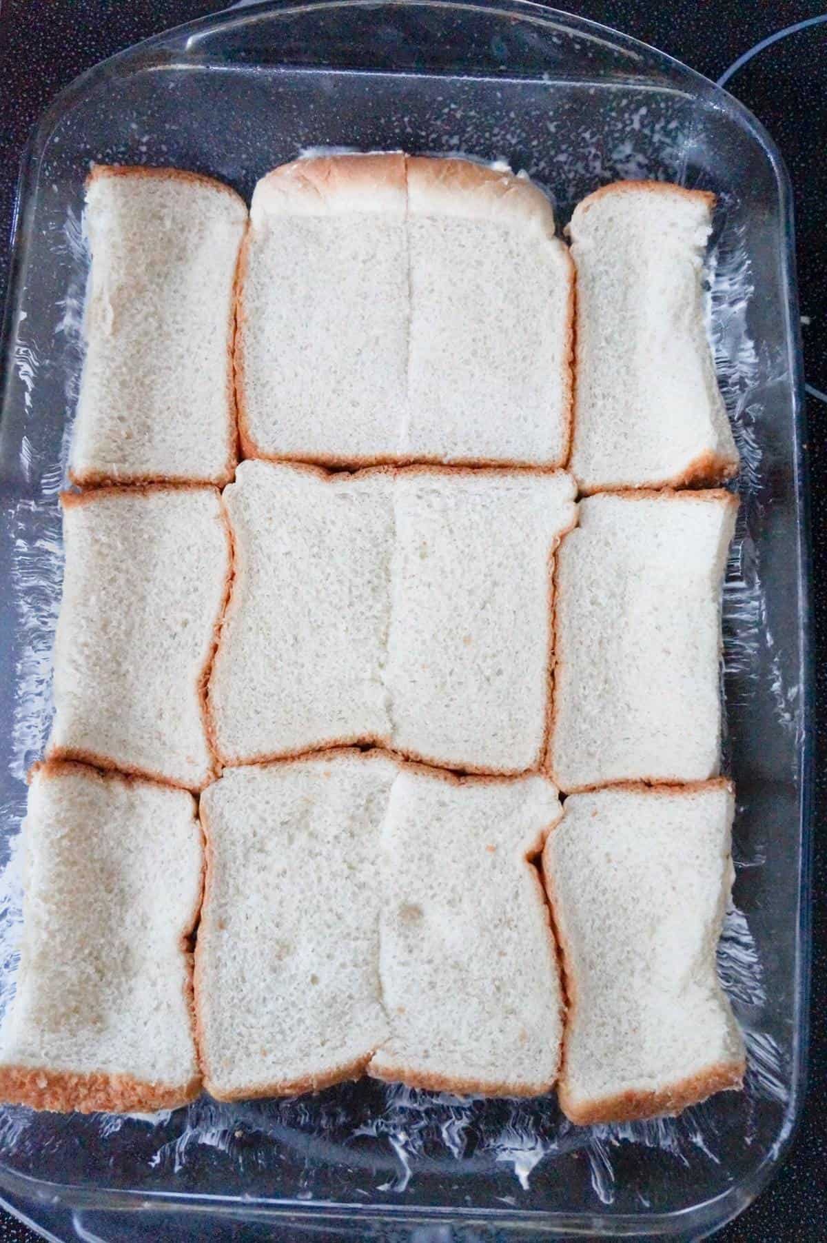 slices of bread in the bottom of a baking dish