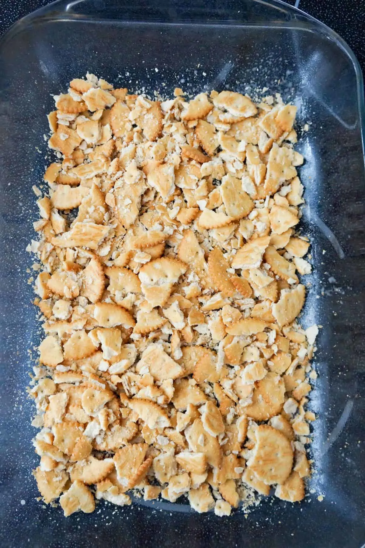 crumbled Ritz crackers in the bottom of a baking dish