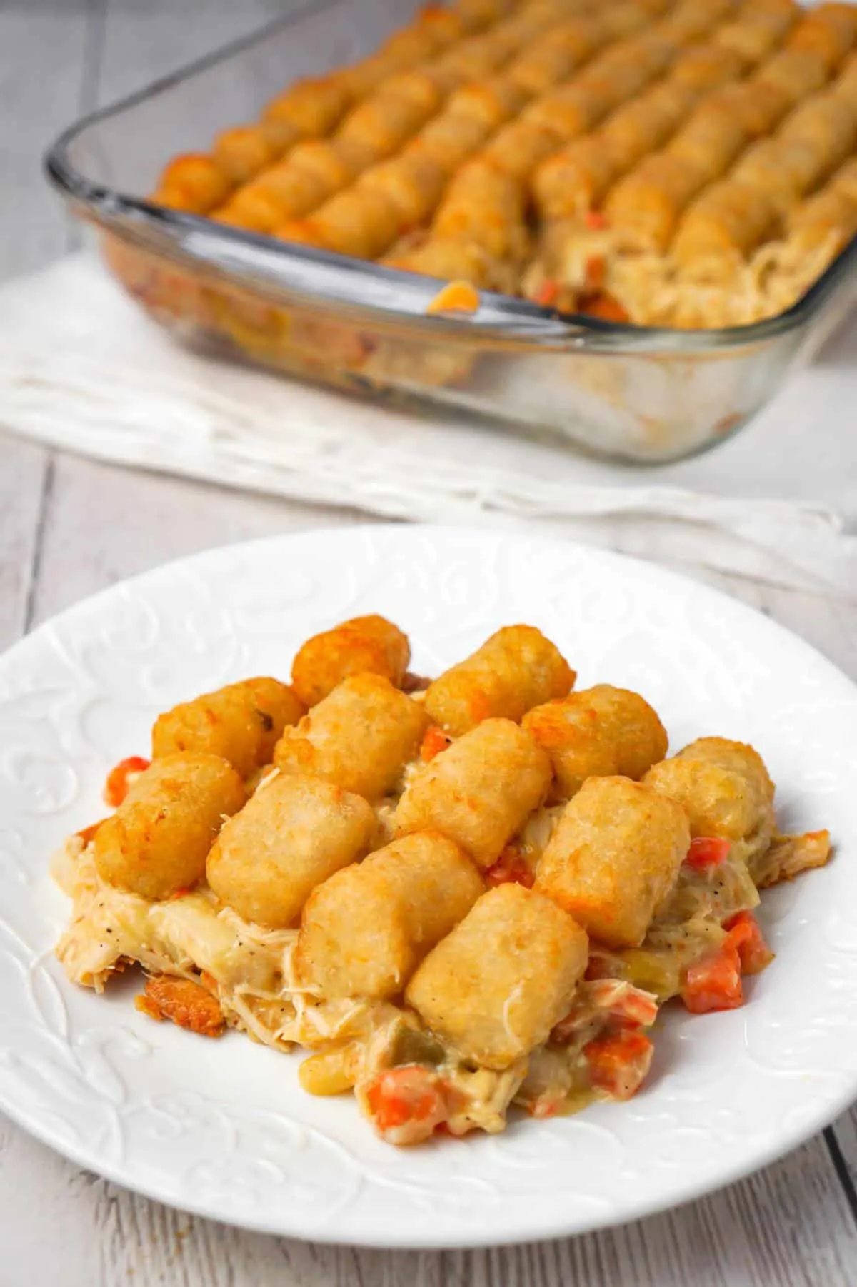 Chicken Pot Pie Tater Tot Casserole is an easy dinner recipe using shredded rotisserie chicken tossed with cream of chicken soup and mixed veggies all topped with tater tots.
