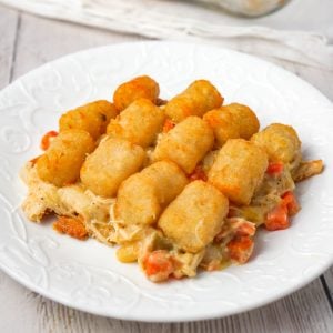 Chicken Pot Pie Tater Tot Casserole is an easy dinner recipe using shredded rotisserie chicken tossed with cream of chicken soup and mixed veggies all topped with tater tots.