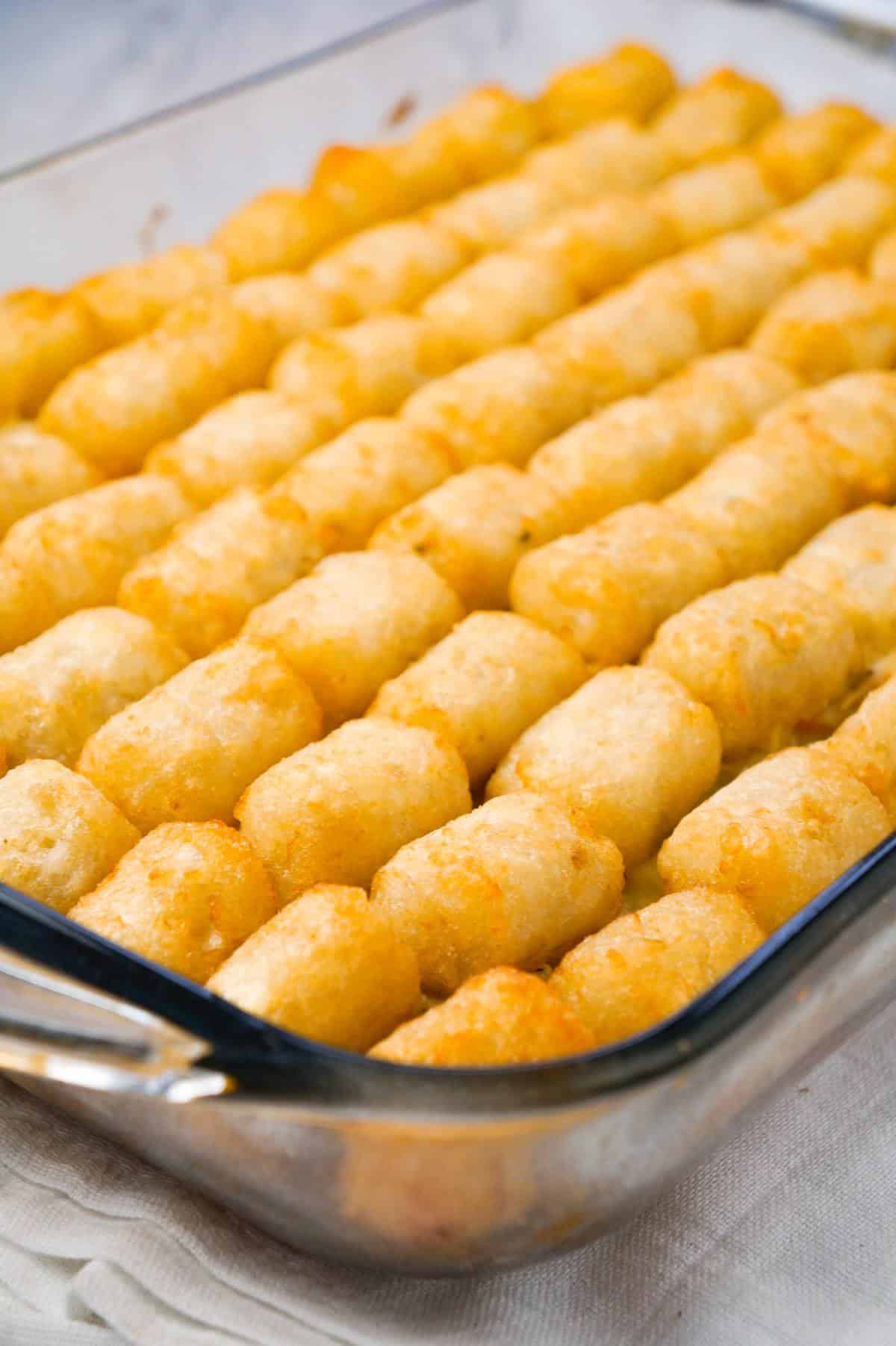 Chicken Pot Pie Tater Tot Casserole is an easy dinner recipe using shredded rotisserie chicken tossed with cream of chicken soup and mixed veggies all topped with tater tots.