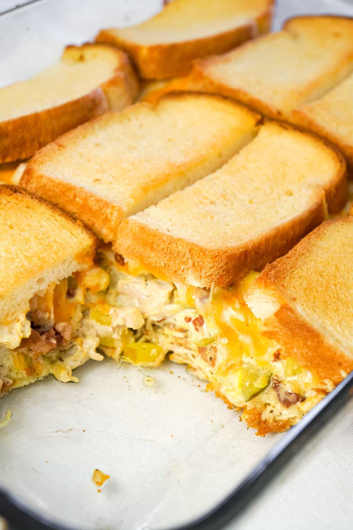 Dill Pickle Chicken Grilled Cheese Casserole is a delicious dinner recipe loaded with shredded chicken, diced dill pickles, crumbled bacon, ranch dressing and cheese all in between layers of toasted bread.