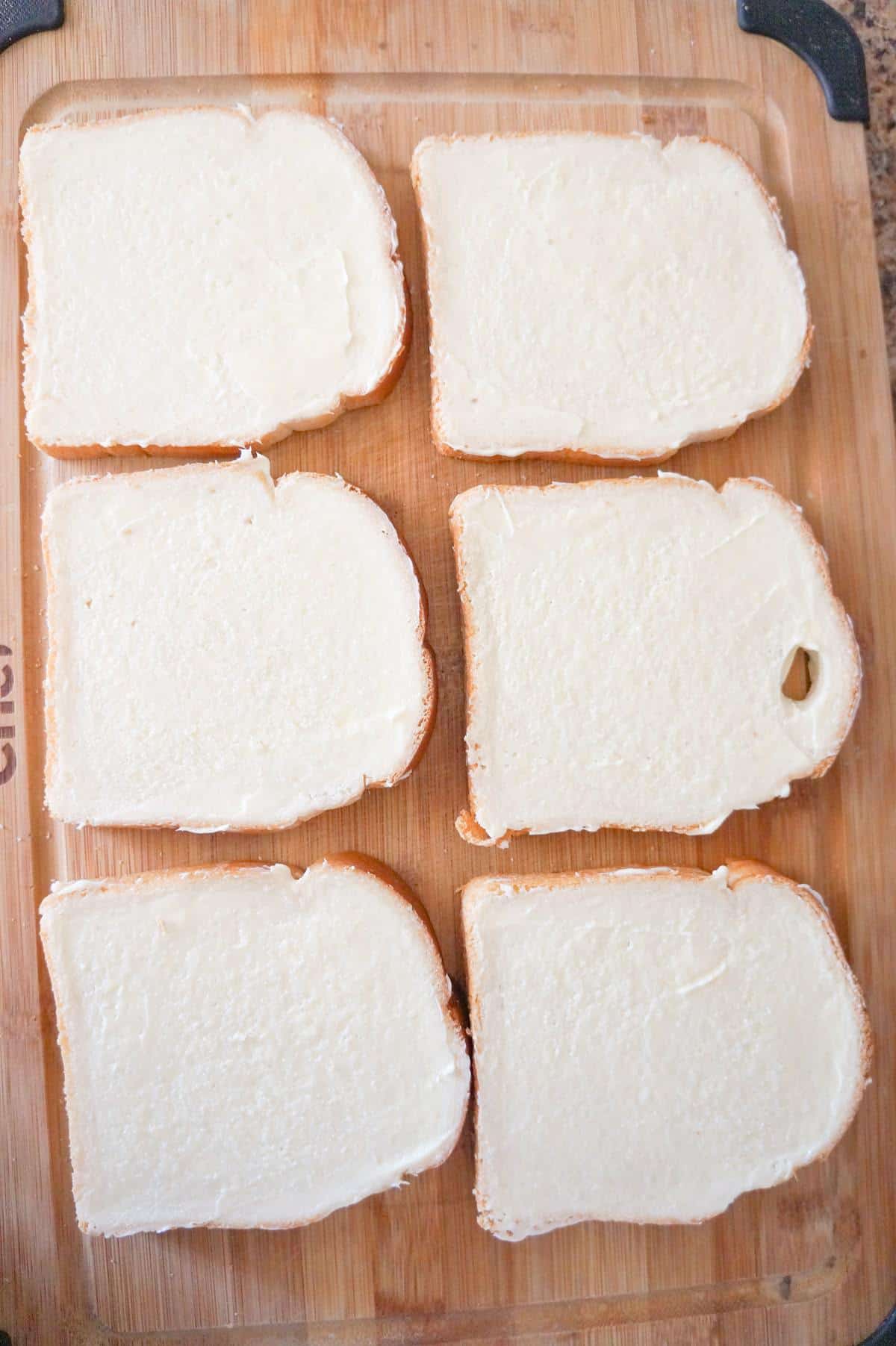 bread slices spread with margarine on a cutting board