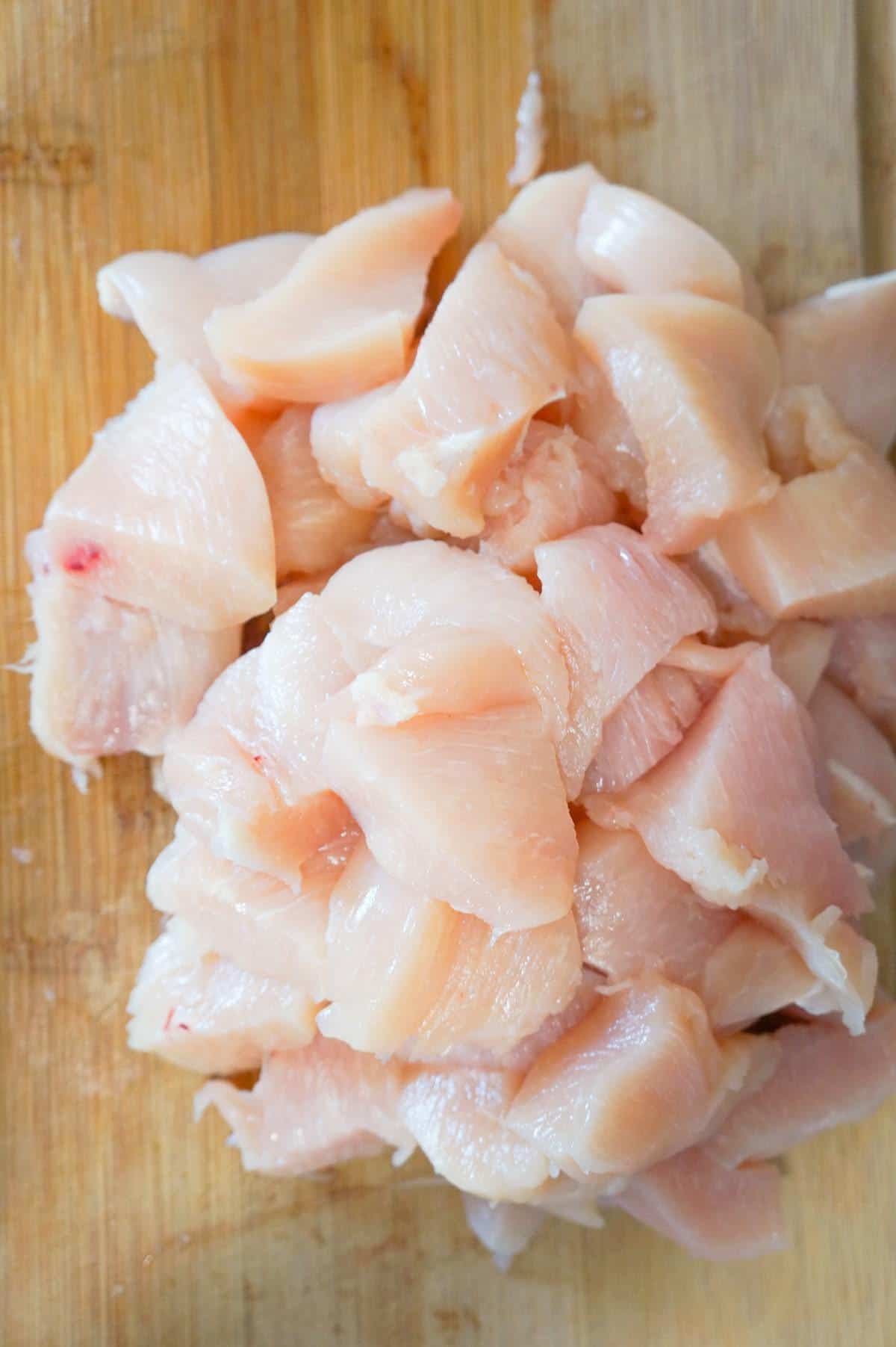 raw chicken breast chunks on a cutting board