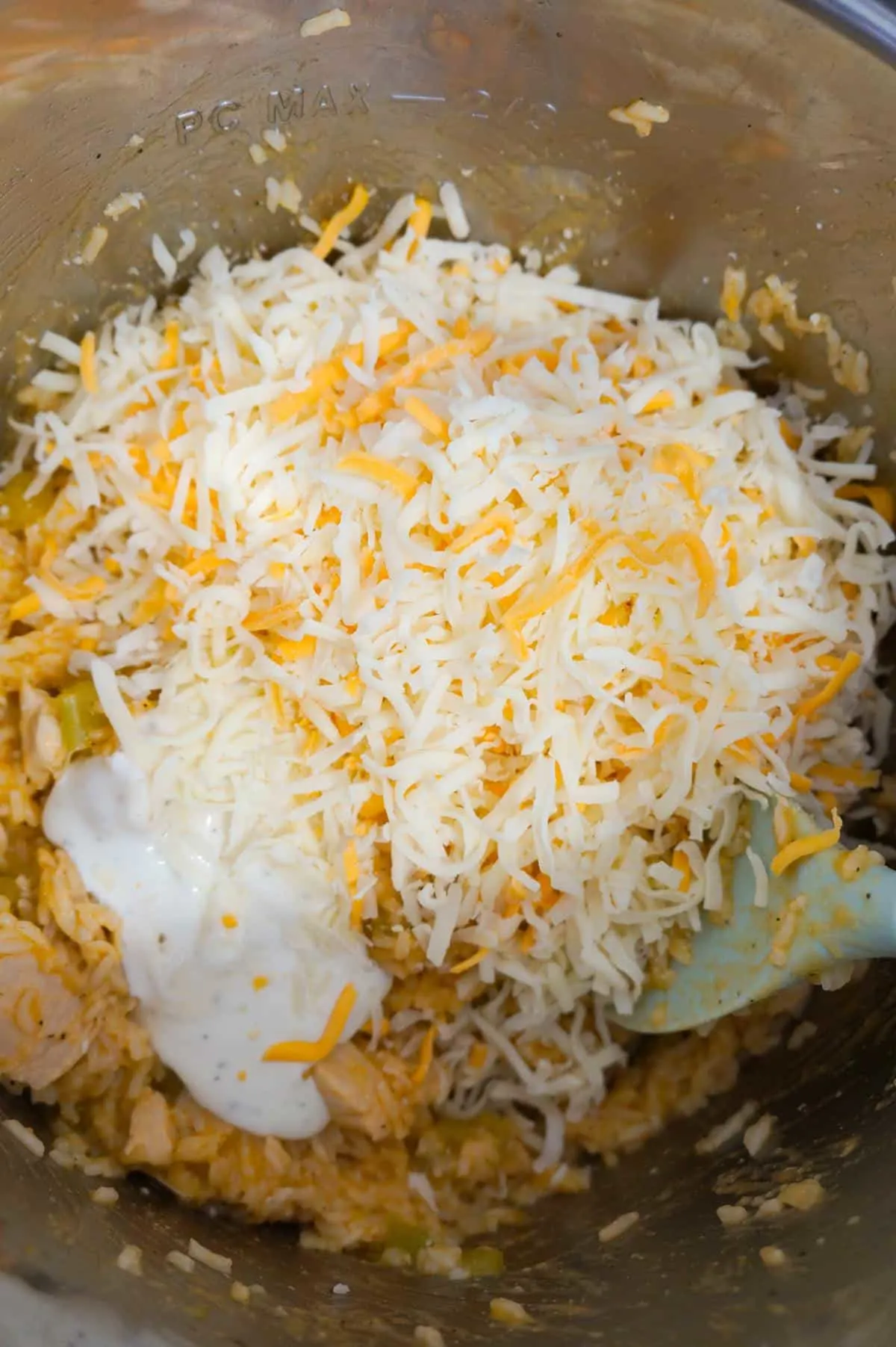 shredded cheese and ranch dressing on top of chicken and rice in an Instant Pot