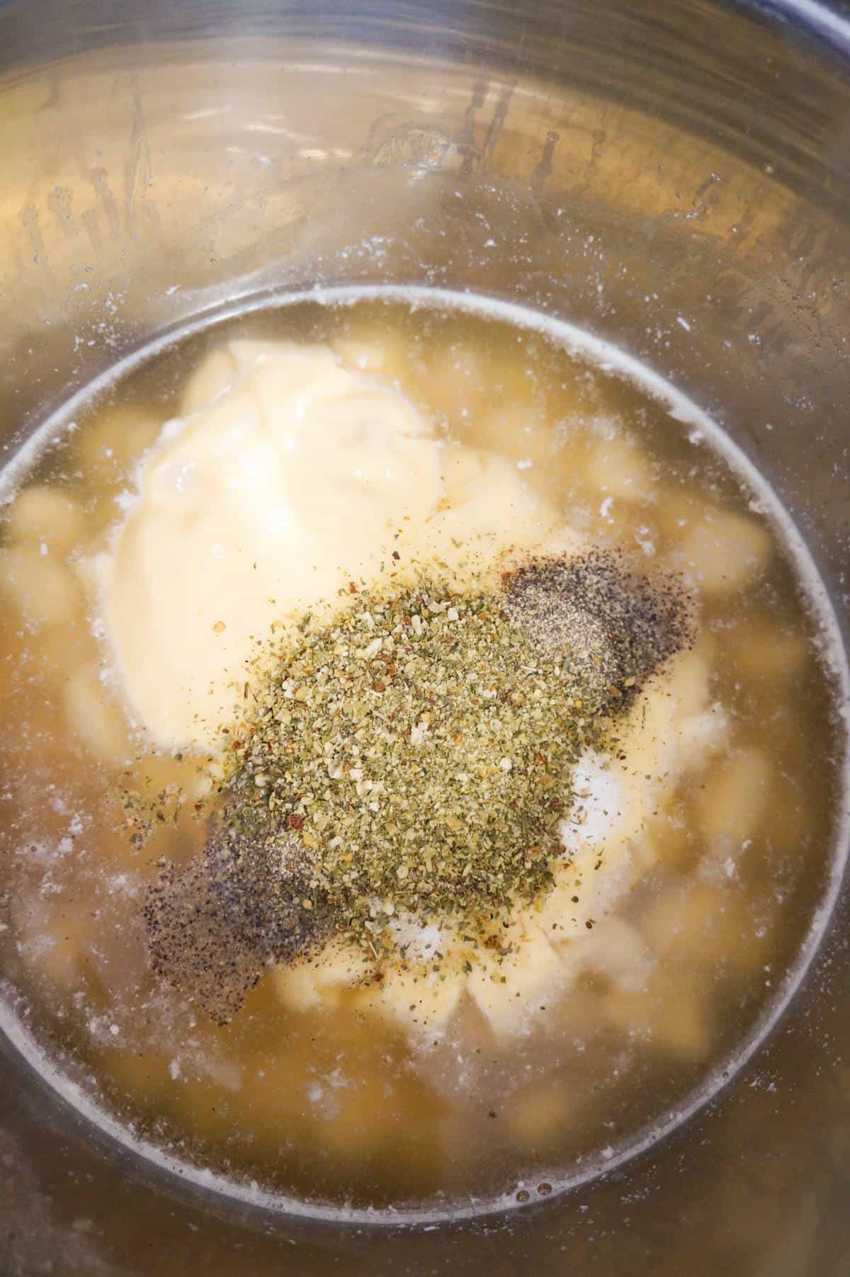 spices on top of cream of chicken soup, broth and potato gnocchi in an Instant Pot