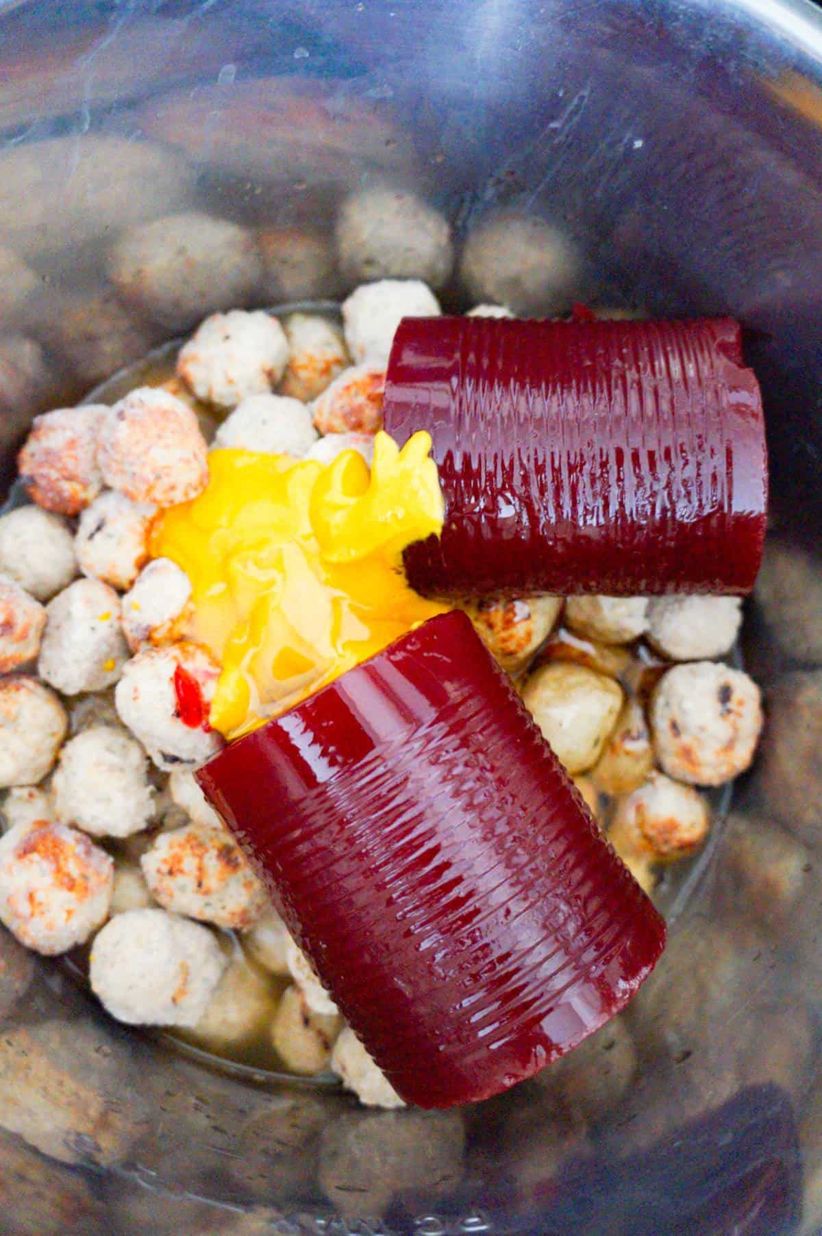 cranberry sauce and mustard on top of frozen turkey meatballs in an Instant Pot