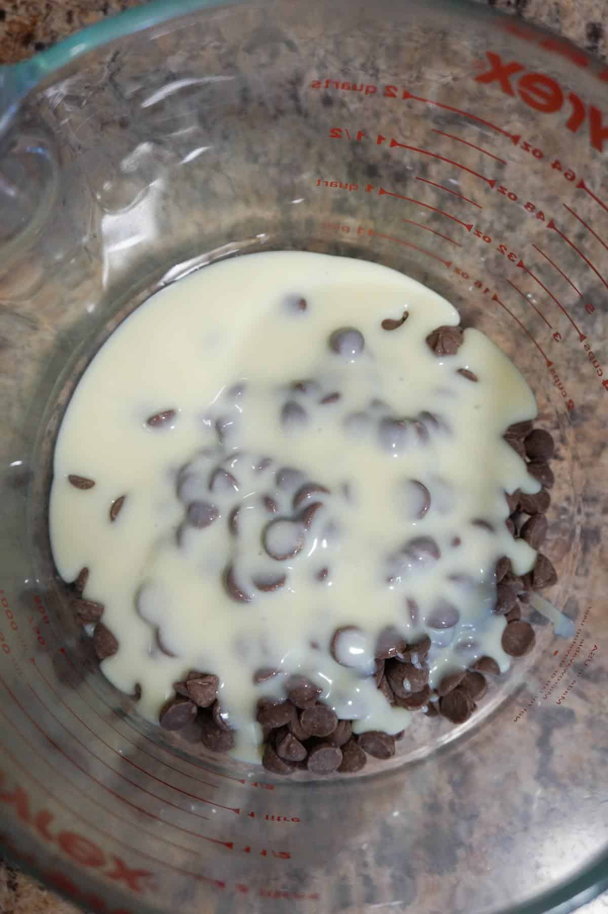 sweetened condensed milk and milk chocolate chips in a glass bowl