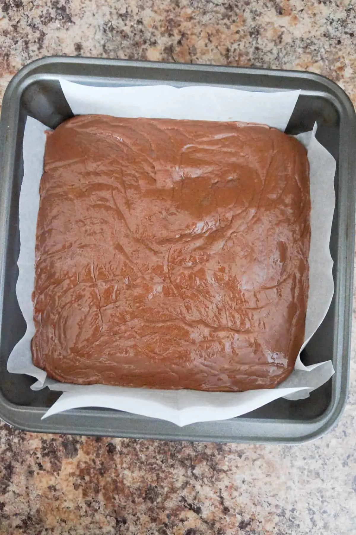 chocolate fudge mixture in a parchment lined baking dish