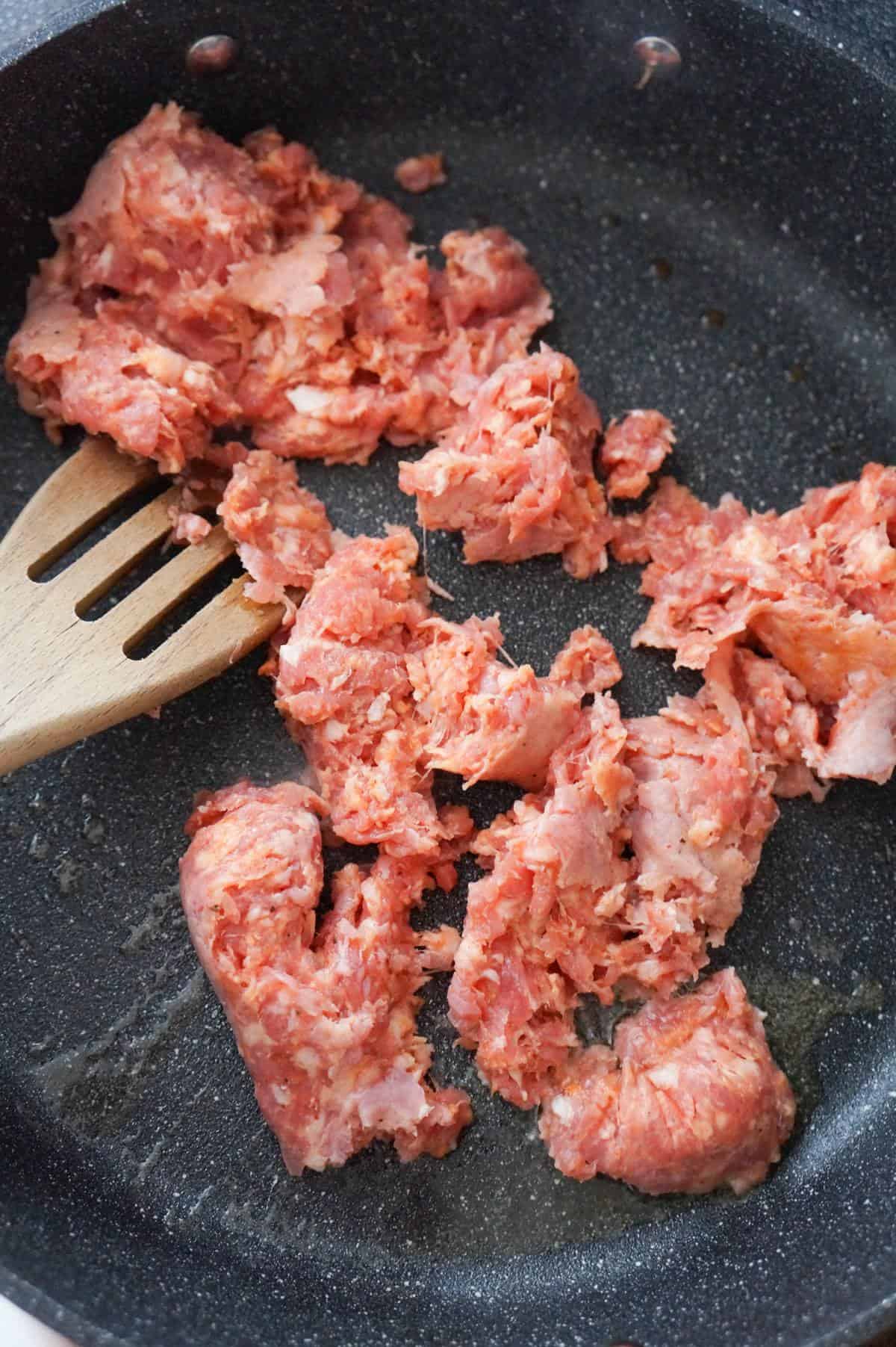 raw Italian sausage meat in a saute pan