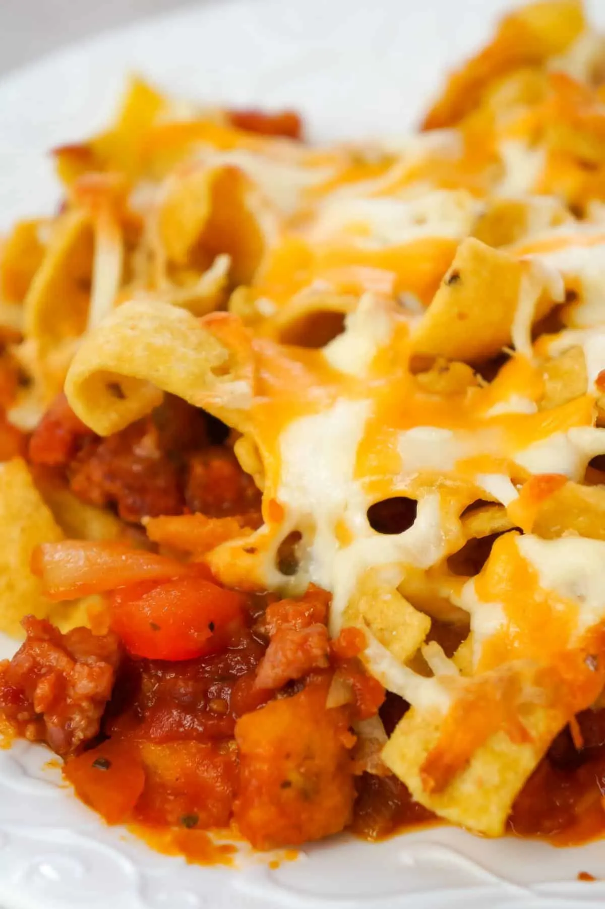 Sausage and Peppers Frito Pie is a delicious casserole recipe made with Italian pork sausage meat, onions and bell pepper tossed in a sweet and spicy tomato sauce and topped with Fritos corn chips and shredded cheese.