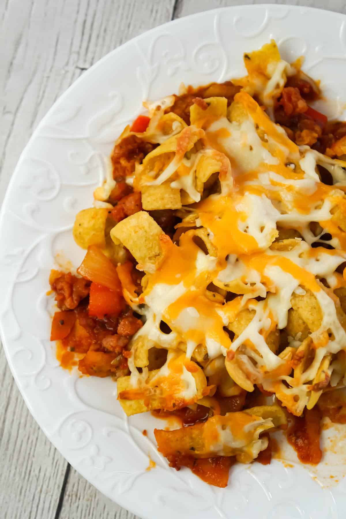 Sausage and Peppers Frito Pie is a delicious casserole recipe made with Italian pork sausage meat, onions and bell pepper tossed in a sweet and spicy tomato sauce and topped with Fritos corn chips and shredded cheese.