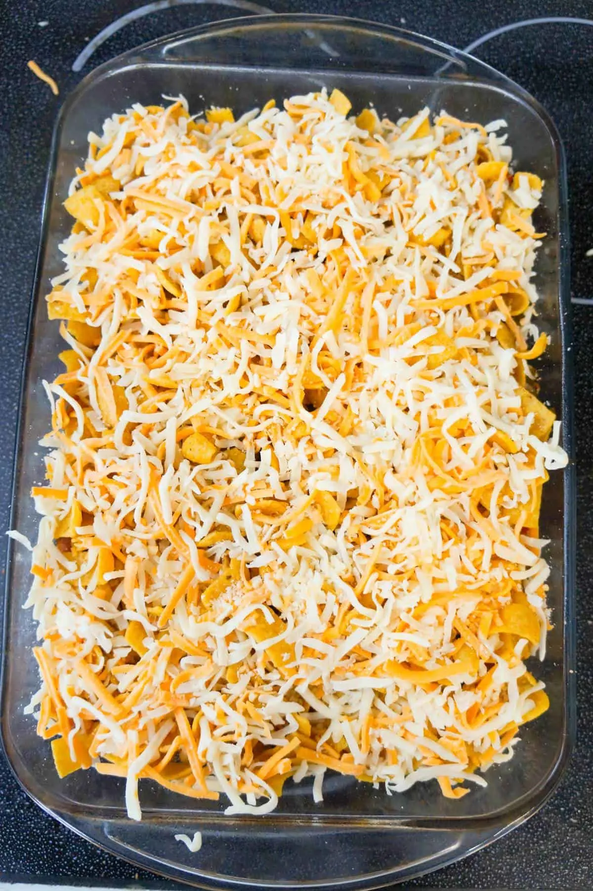 shredded mozzarella and cheddar cheese on top of frito pie