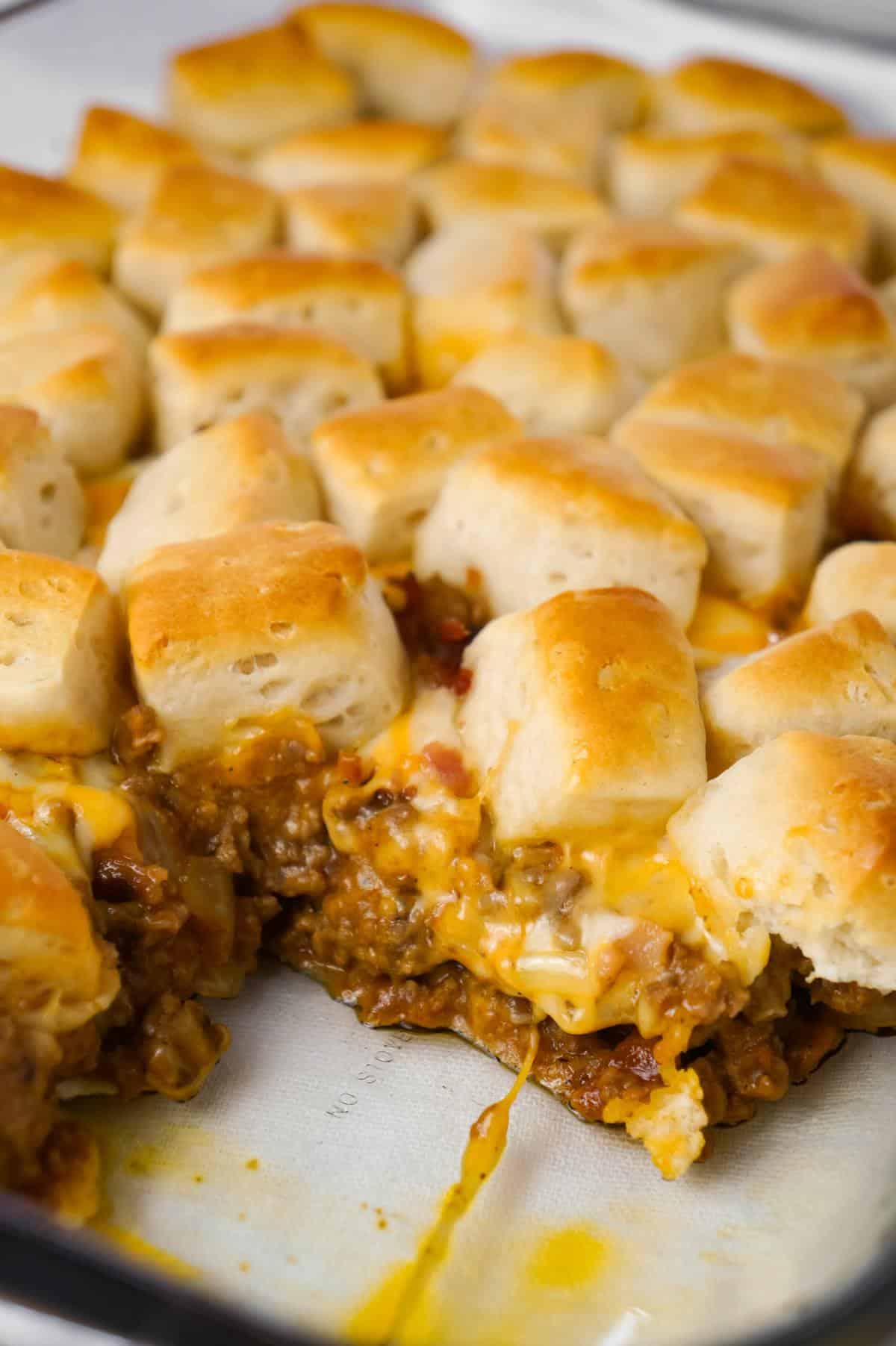 Bacon Cheeseburger Biscuit Casserole is an easy ground beef dinner recipe loaded with diced onions, condensed cheddar cheese soup, ketchup, mustard, crumbled bacon and shredded cheese all topped with pieces of Pillsbury biscuits.
