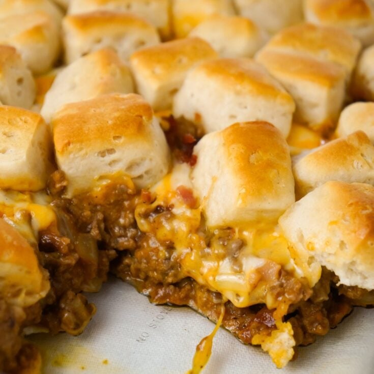 Bacon Cheeseburger Biscuit Casserole is an easy ground beef dinner recipe loaded with diced onions, condensed cheddar cheese soup, ketchup, mustard, crumbled bacon and shredded cheese all topped with pieces of Pillsbury biscuits.