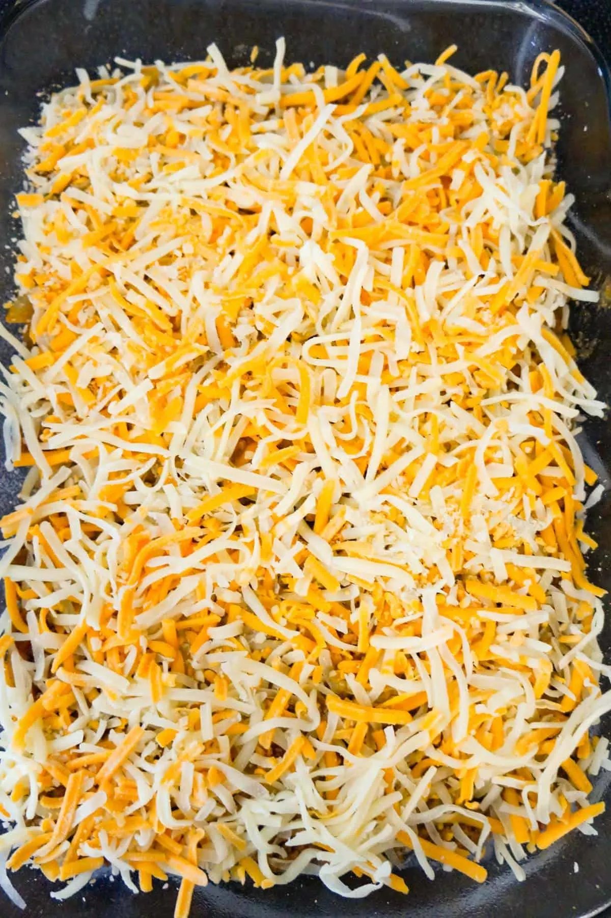 shredded cheese on top of hamburger casserole before baking