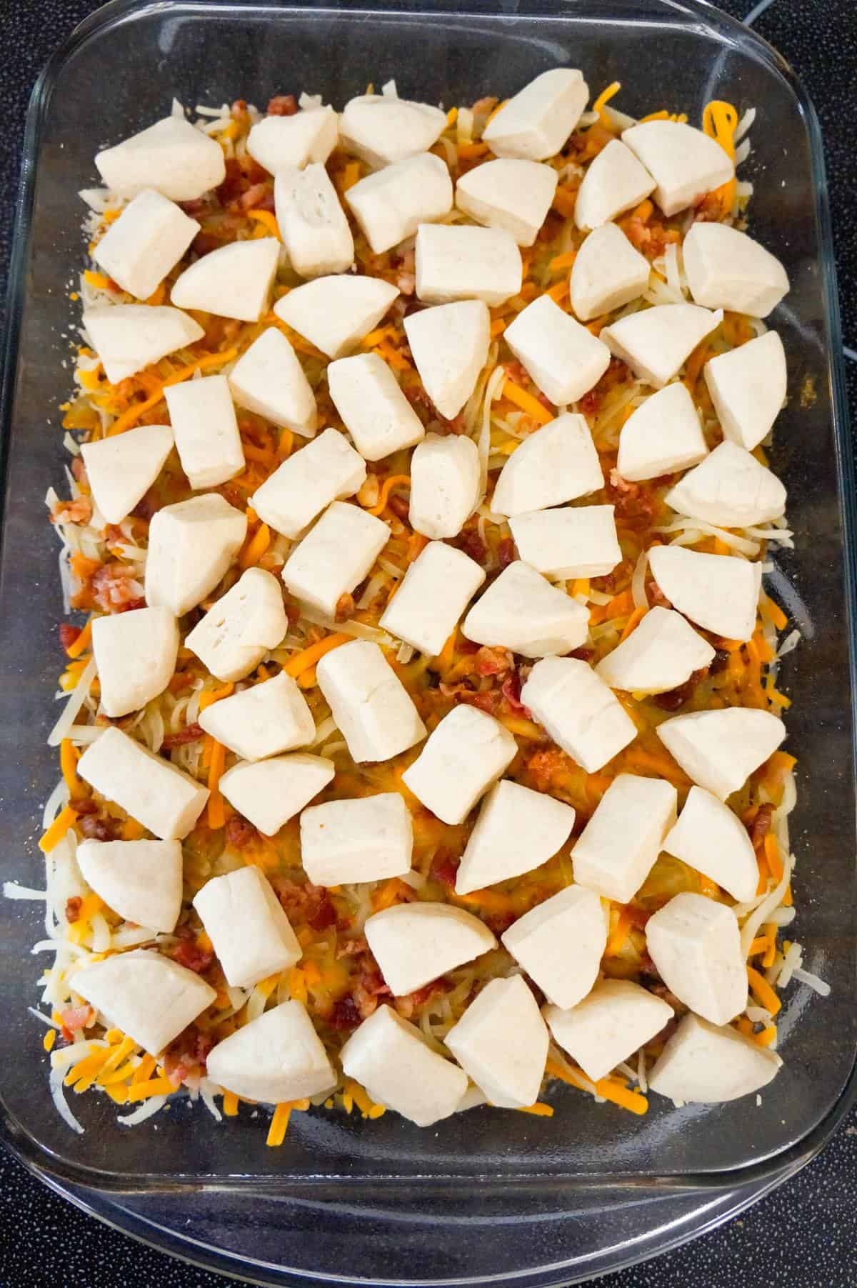 Pillsbury biscuit dough pieces on top of bacon cheeseburger casserole before baking