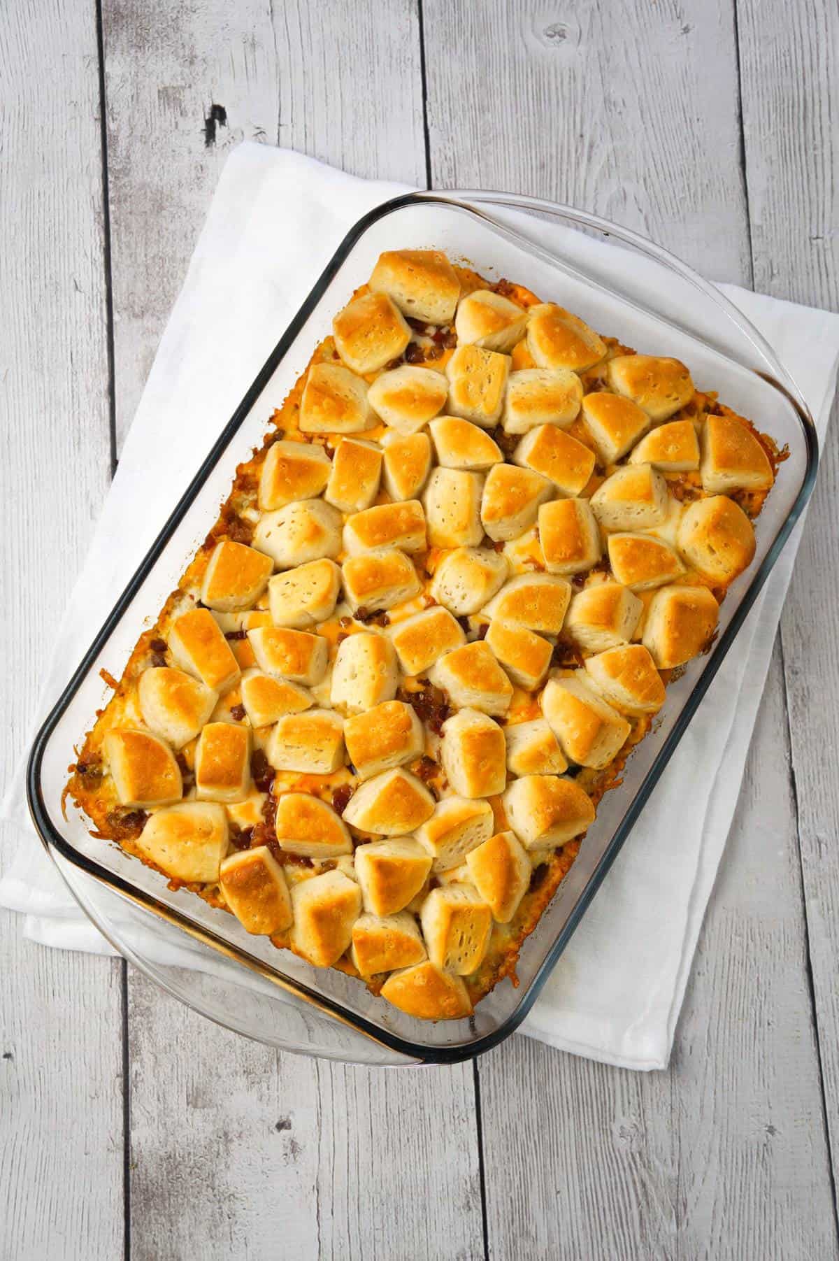 Bacon Cheeseburger Biscuit Casserole is an easy ground beef dinner recipe loaded with diced onions, condensed cheddar cheese soup, ketchup, mustard, crumbled bacon and shredded cheese all topped with pieces of Pillsbury biscuits.