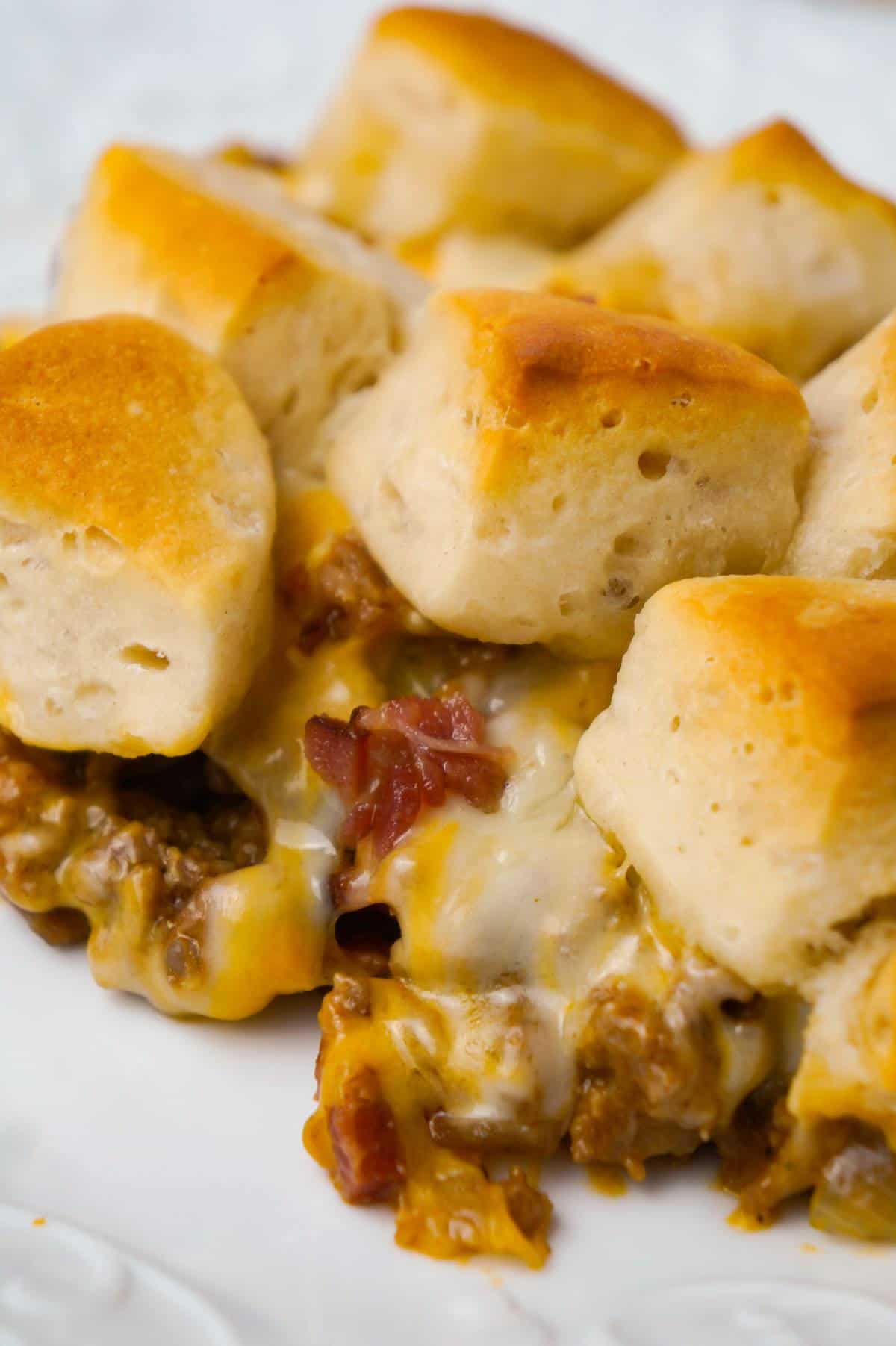 Bacon Cheeseburger Biscuit Casserole is an easy ground beef dinner recipe loaded with diced onions, condensed cheddar cheese soup, ketchup, mustard, crumbled bacon and shredded cheese all topped with pieces of Pillsbury biscuits.