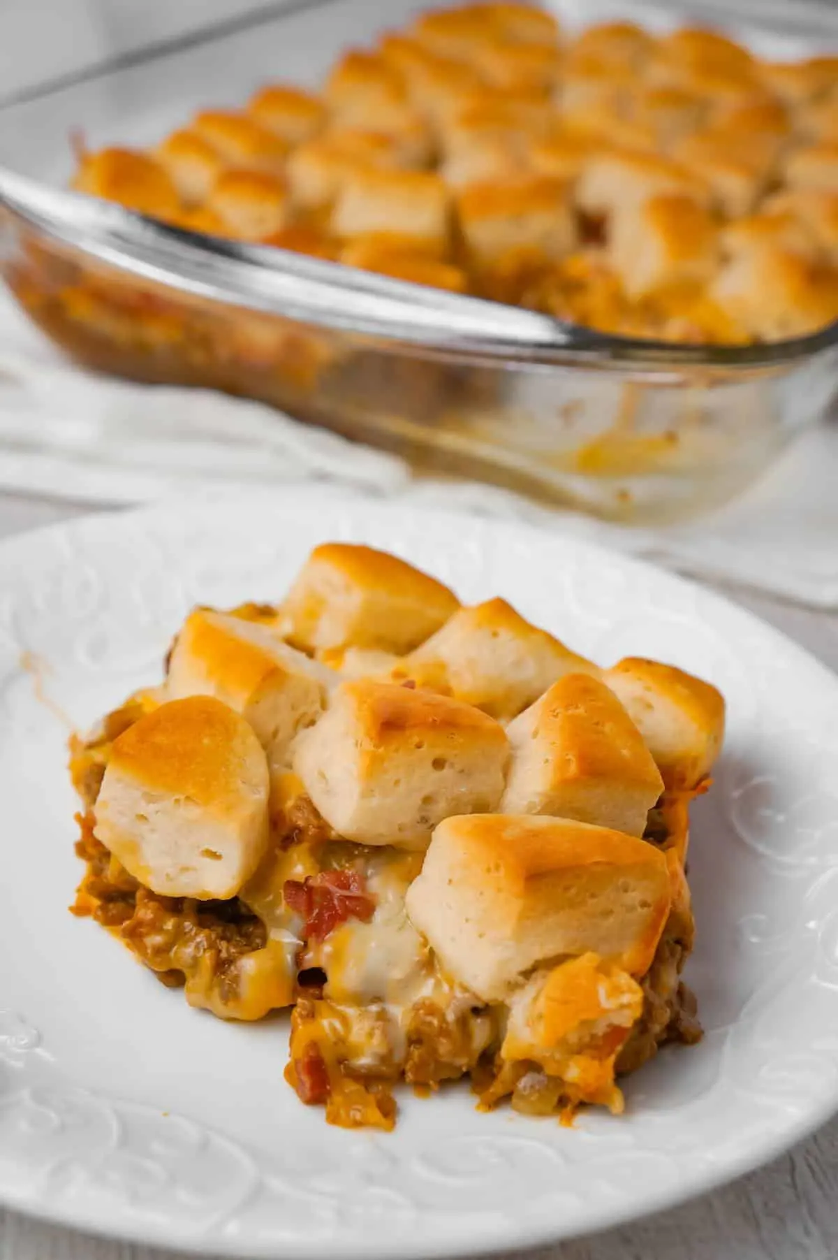 Bacon Cheeseburger Biscuit Casserole is an easy ground beef dinner recipe loaded with diced onions, condensed cheddar cheese soup, ketchup, mustard, crumbled bacon and shredded cheese all topped with pieces of Pillsbury biscuits.