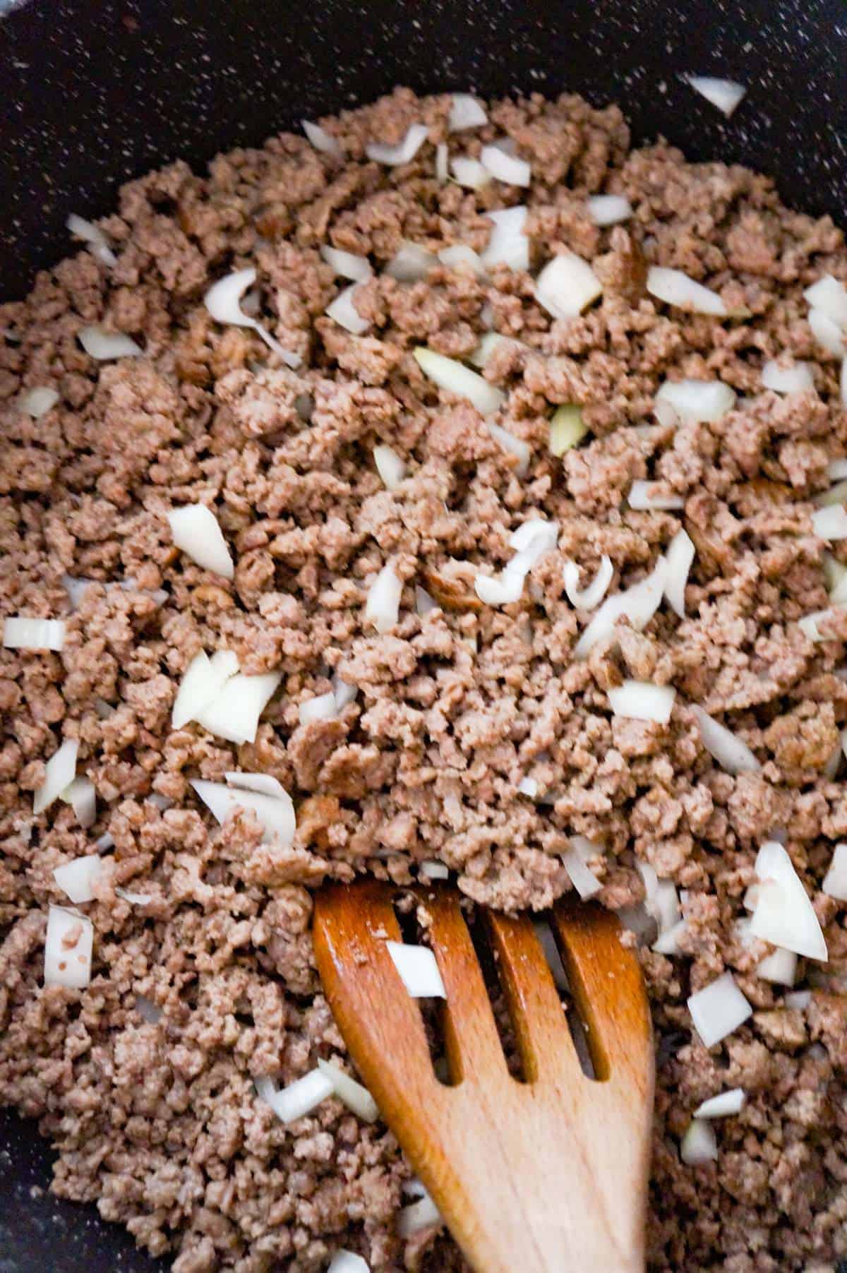 ground beef and diced onions in a saute pan