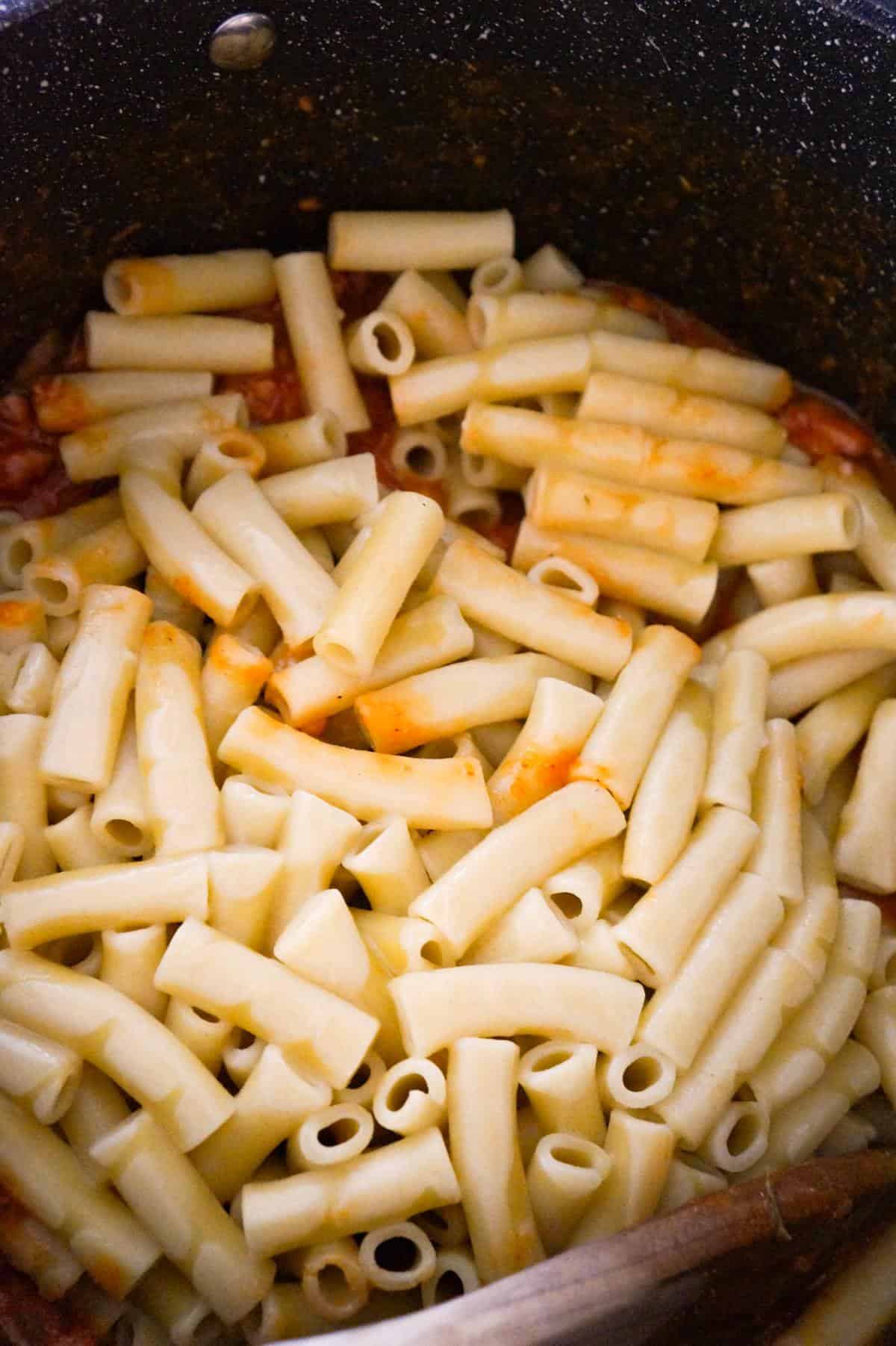 zit noodles on top of marinara sauce in a large pot