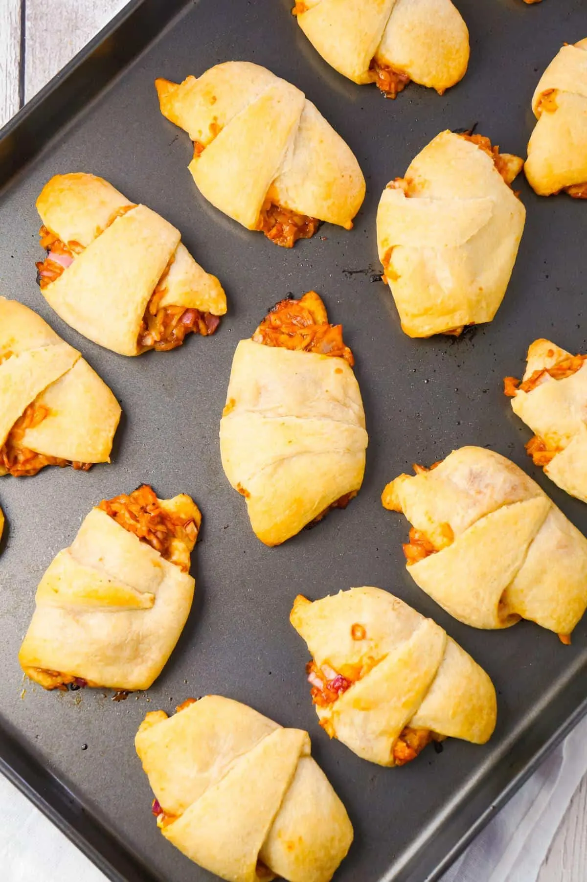 BBQ Chicken Crescent Rolls are an easy weeknight dinner recipe using shredded rotisserie chicken, diced red onions, Sweet Baby Ray's Barbecue sauce, shredded cheese and Pillsbury crescent rolls.