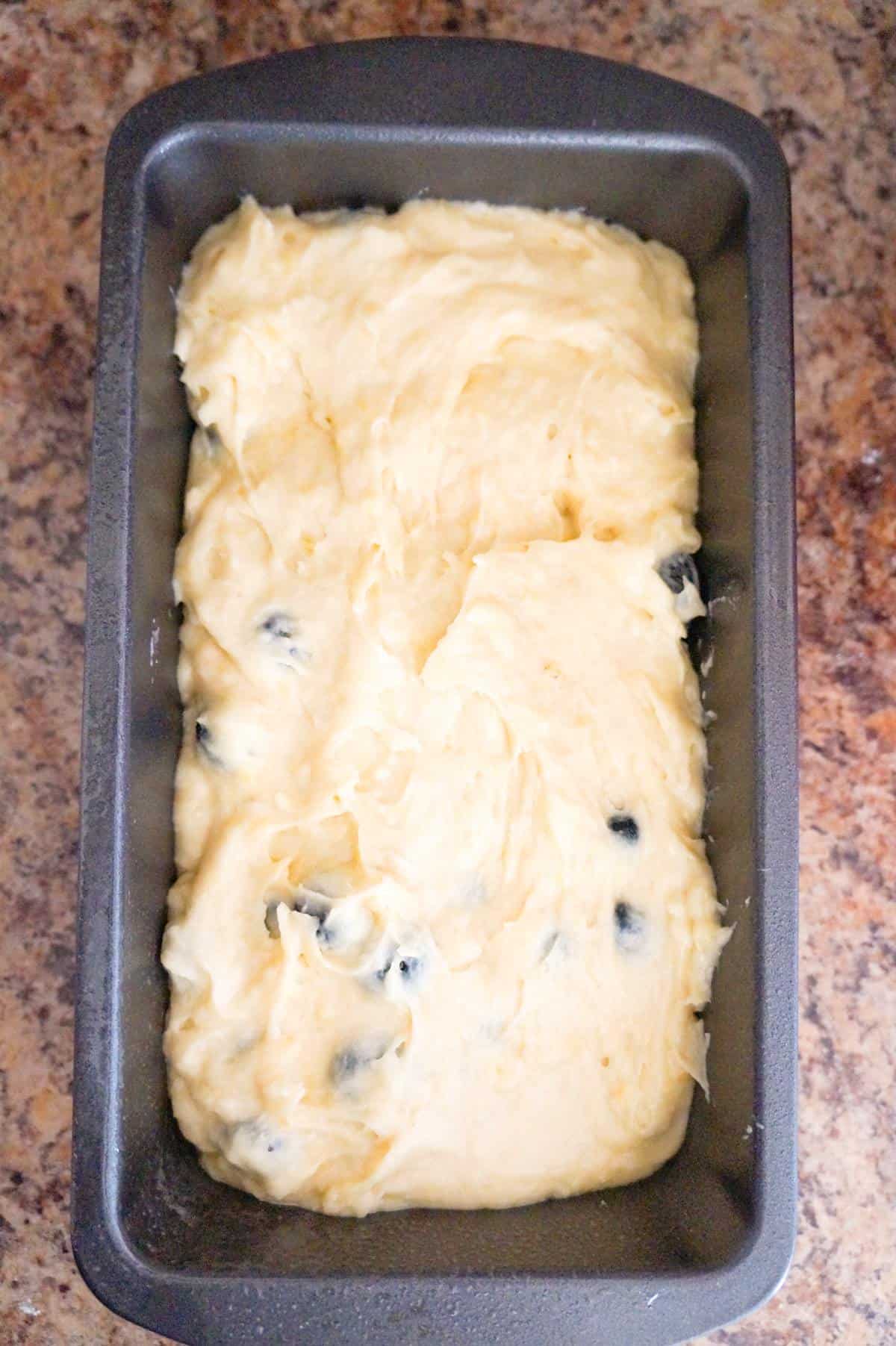 blueberry banana bread batter in a loaf pan