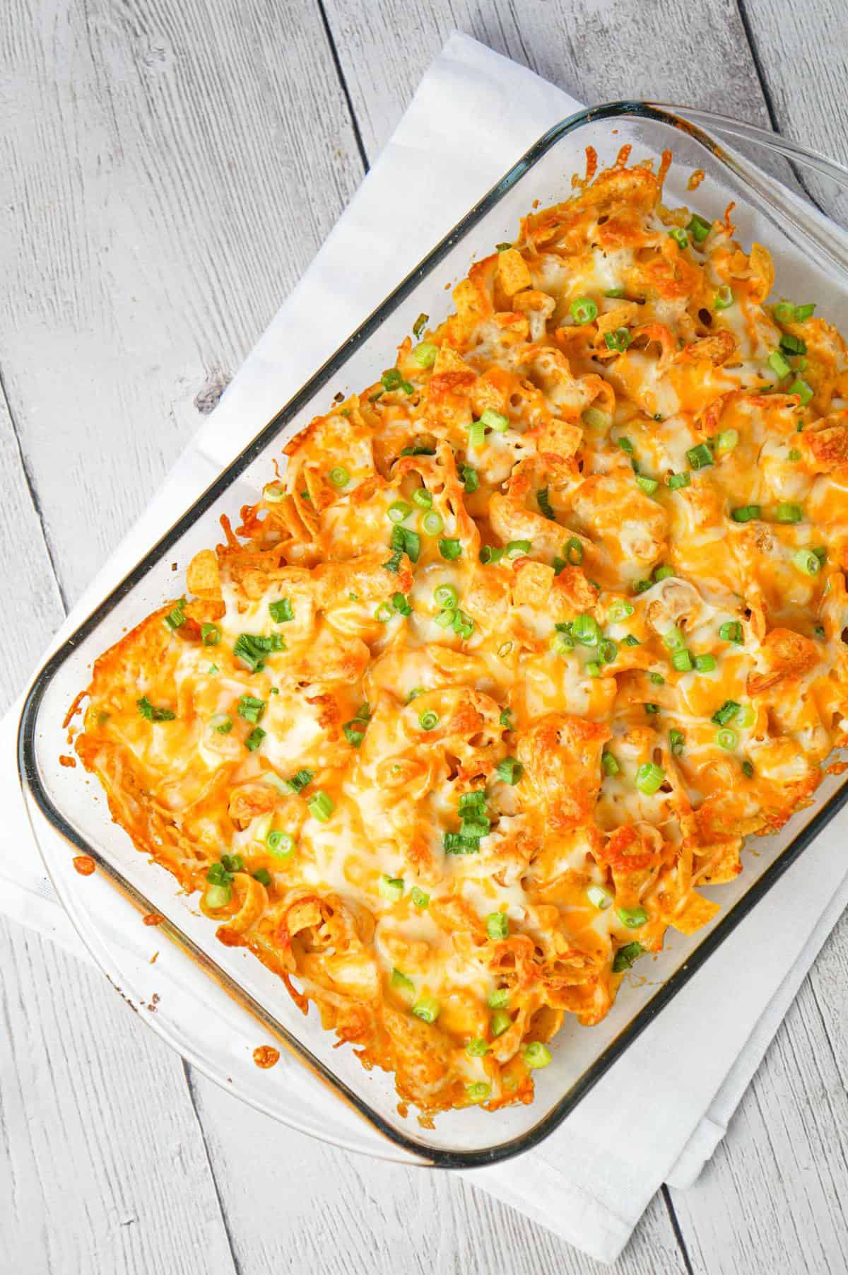 Buffalo Chicken Frito Pie is an easy casserole recipe using shredded rotisserie chicken and diced celery tossed in Buffalo sauce and ranch dressing, all topped with Fritos corn chips and cheese.