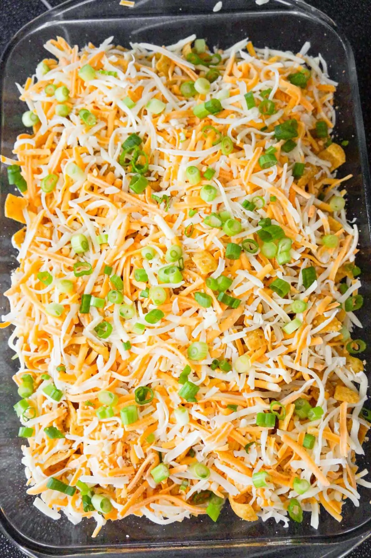 chopped green onions and shredded cheese on top of buffalo frito pie
