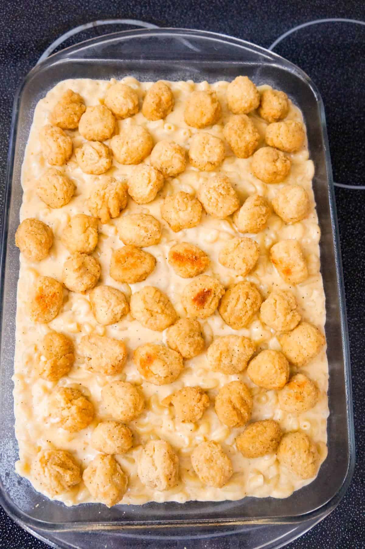 popcorn chicken on top of mac and cheese in a baking dish