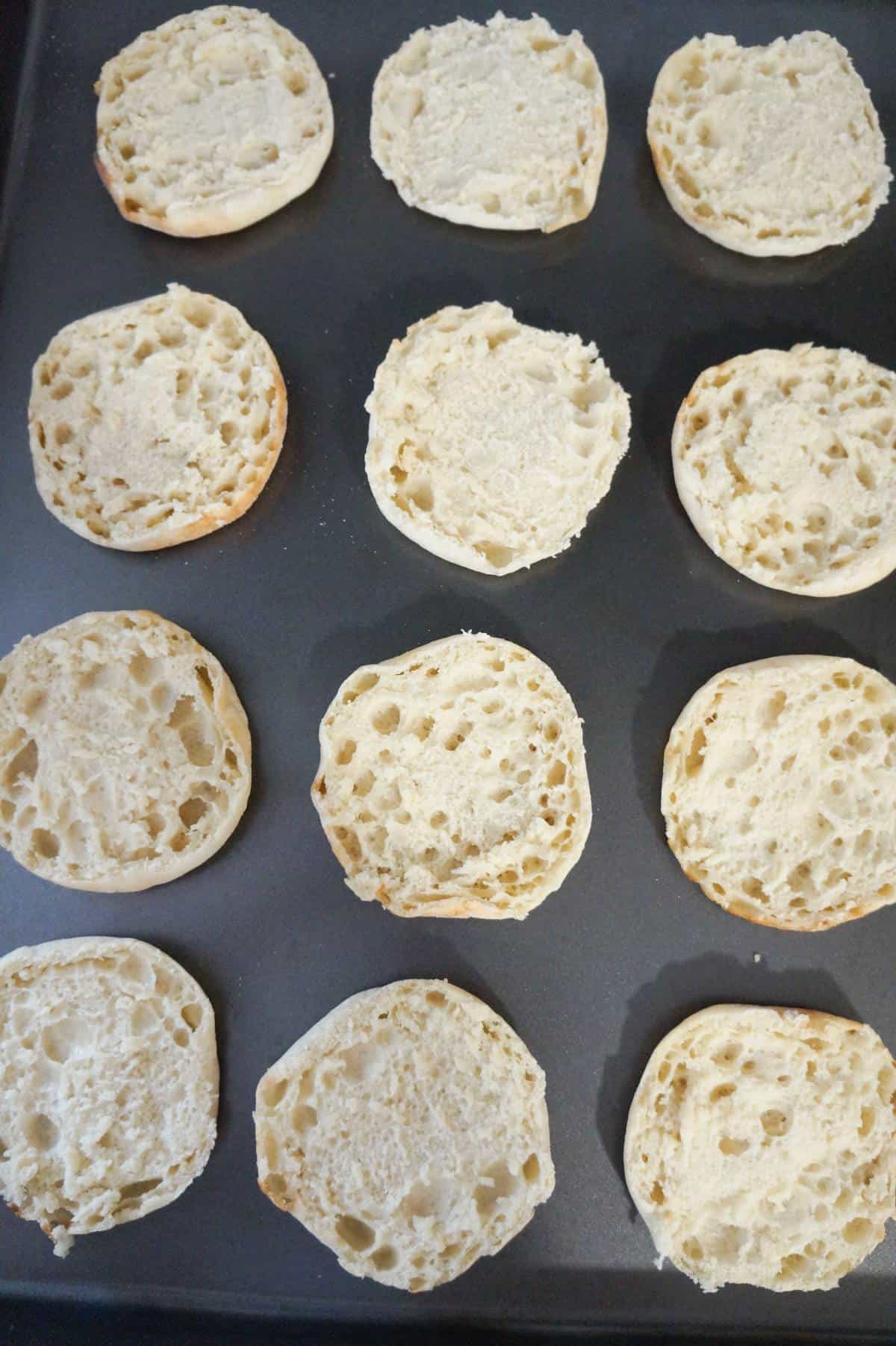 English muffin halves on a baking sheet