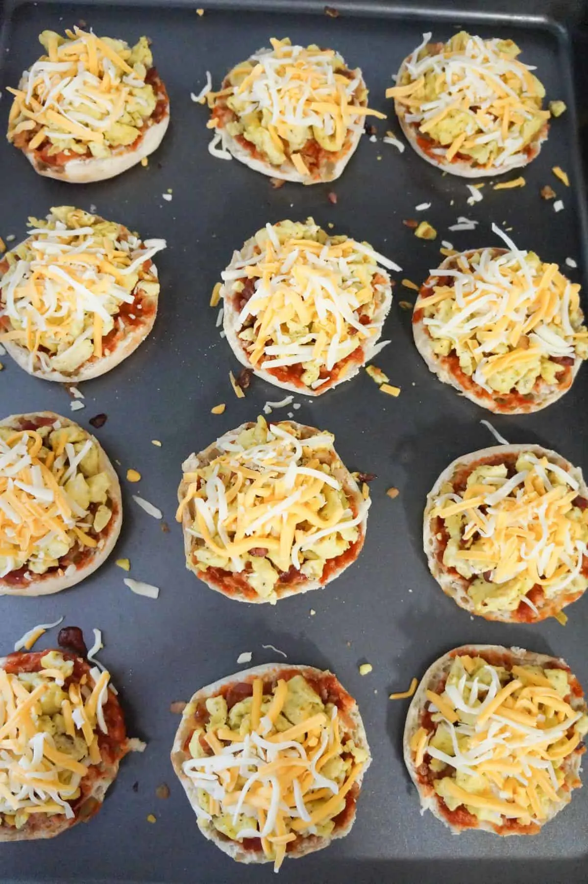 shredded cheese on top of breakfast pizzas before cooking