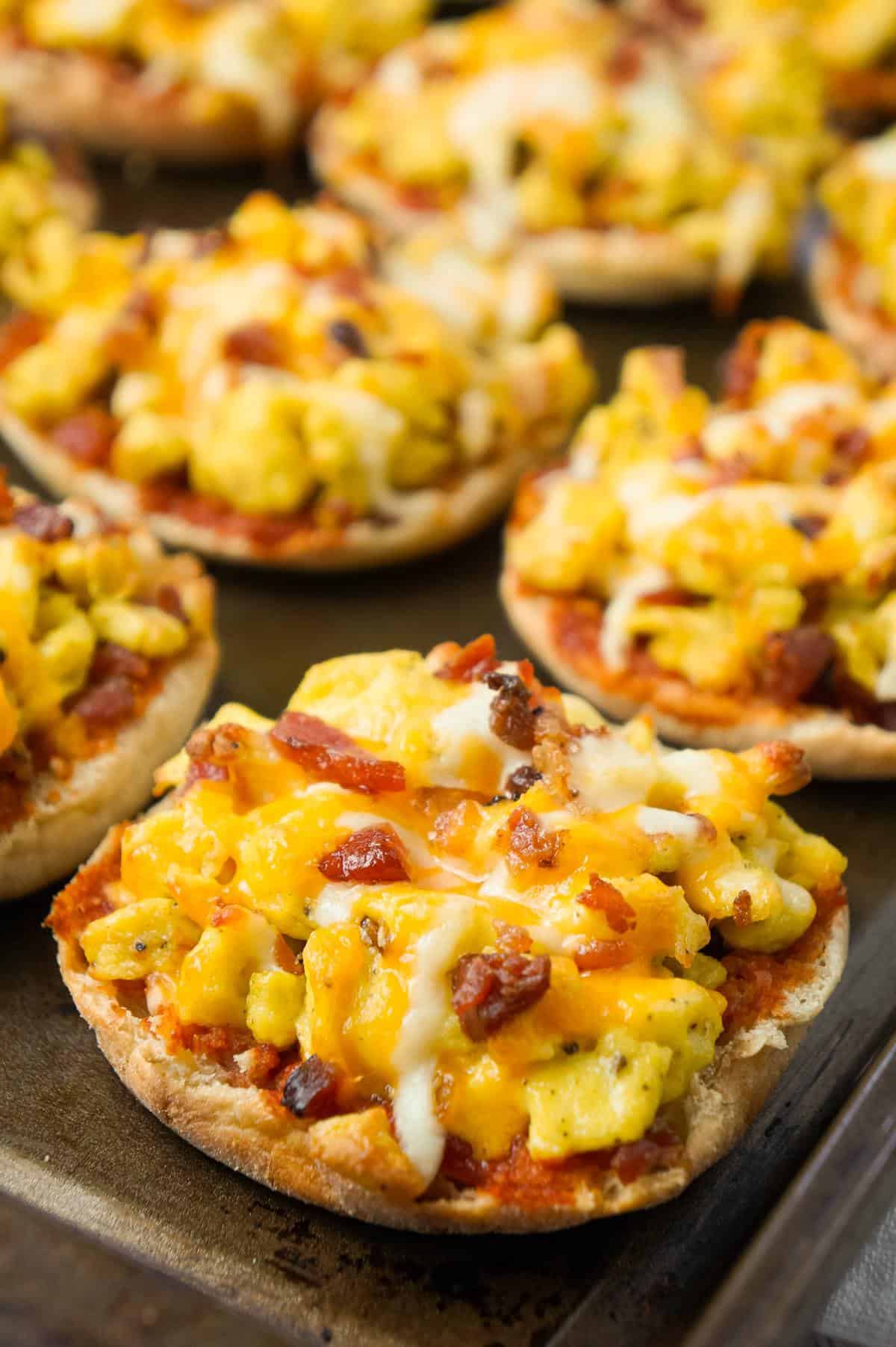 English Muffin Breakfast Pizzas are an easy breakfast or brunch recipe using English muffins and topped with Heinz chili sauce, scrambled eggs, crumbled bacon and shredded cheese.