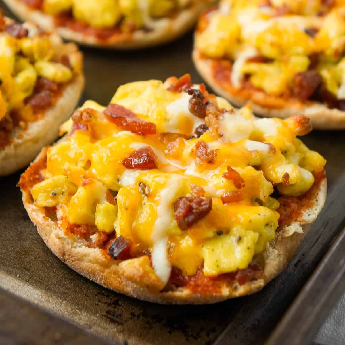 English Muffin Breakfast Pizzas are an easy breakfast or brunch recipe using English muffins and topped with Heinz chili sauce, scrambled eggs, crumbled bacon and shredded cheese.