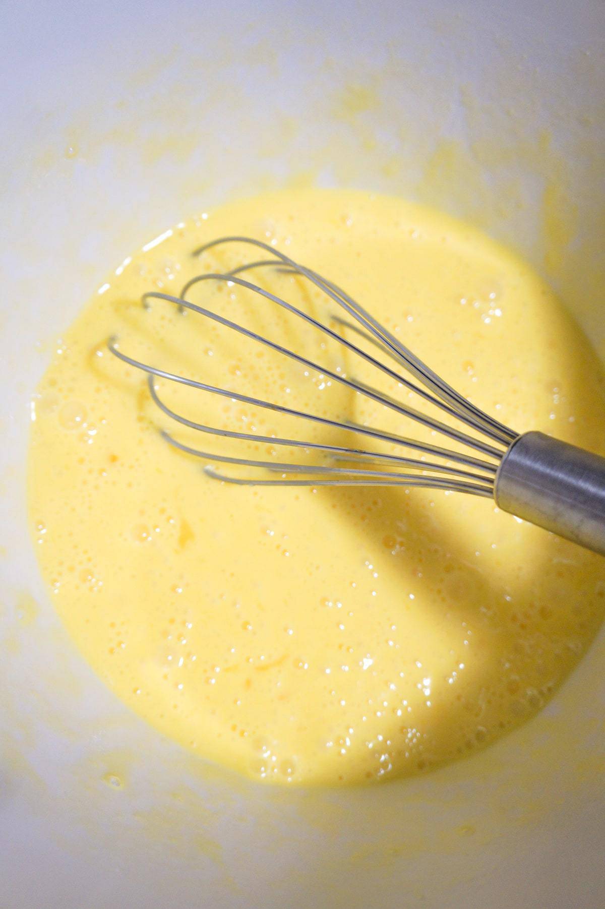 beaten eggs and cream in a mixing bowl