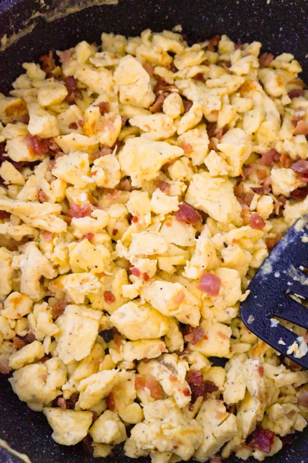 scrambled eggs and crumbled bacon in a saute pan