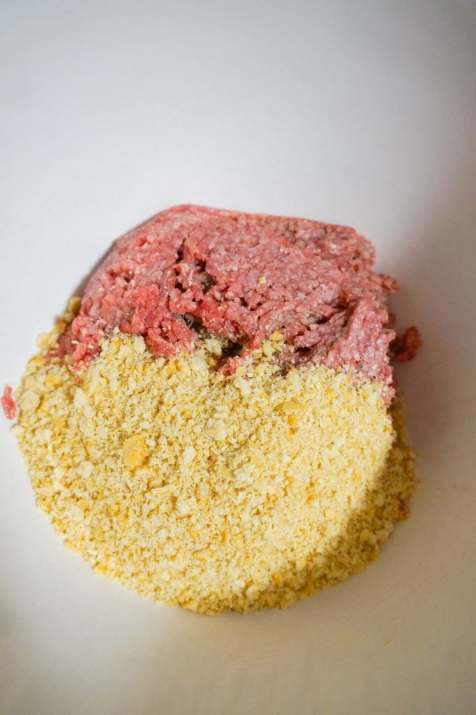 Ritz cracker crumbs and lean ground beef in a mixing bowl