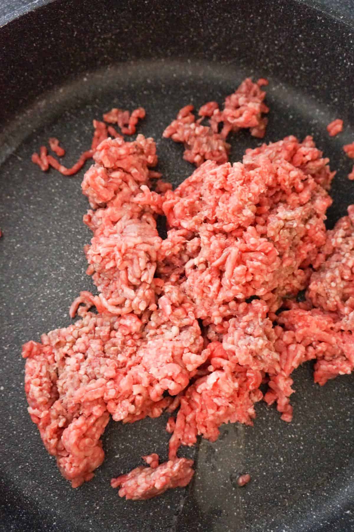 raw ground beef in a saute pan
