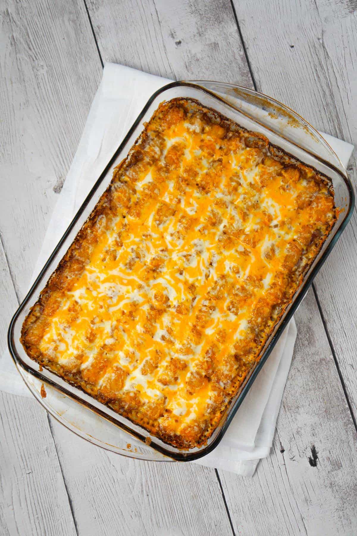 Philly Cheese Steak Tater Tot Casserole is a hearty dinner recipe with a base of ground beef, diced onion, diced green peppers and sliced mushrooms tossed in brown gravy and topped with shredded cheese and tater tots.