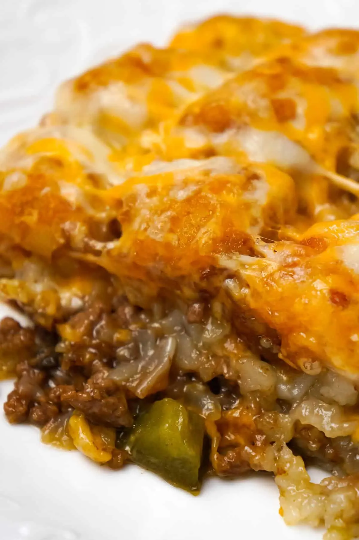 Philly Cheese Steak Tater Tot Casserole is a hearty dinner recipe with a base of ground beef, diced onion, diced green peppers and sliced mushrooms tossed in brown gravy and topped with shredded cheese and tater tots.