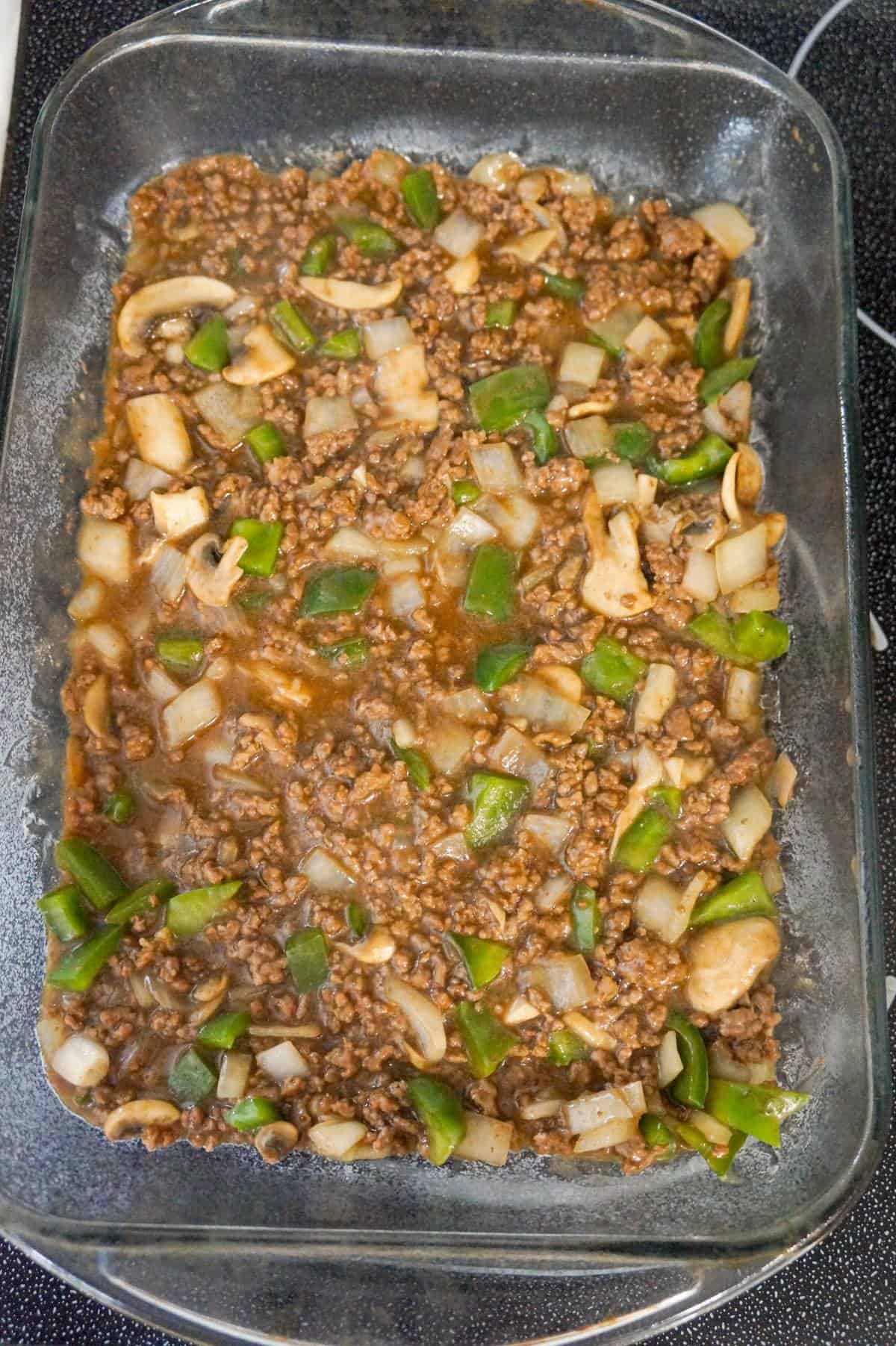 ground beef, green peppers and mushrooms mixture in a baking dish