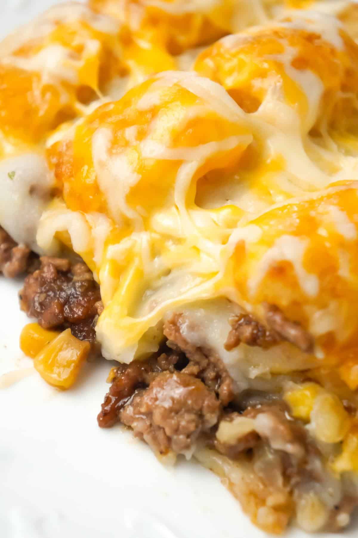 Shepherd's Pie Tater Tot Casserole is a hearty casserole with ground beef, corn and diced onions topped with mashed potatoes, tater tots and shredded cheese.